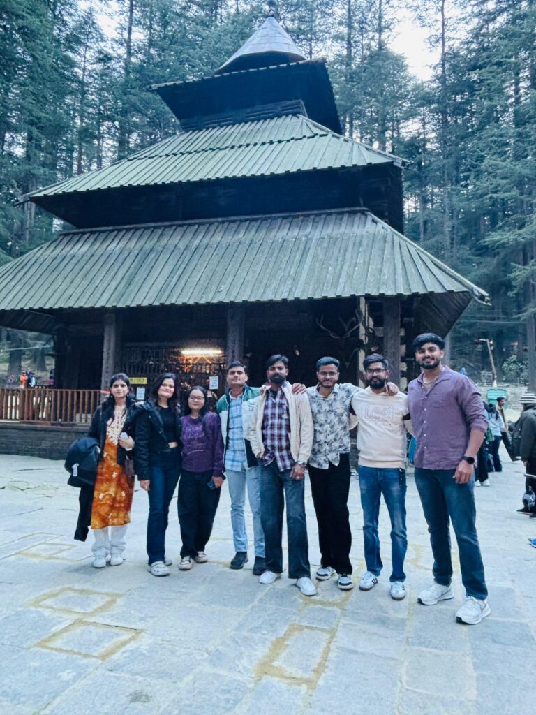 Group tour packages to Manali: Yaarana Safar travellers in front of the wooden Hadimba Devi Temple